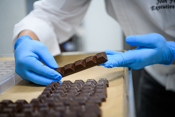 Executive Chef Josh Fink holding a bar of Nove luxury chocolates.