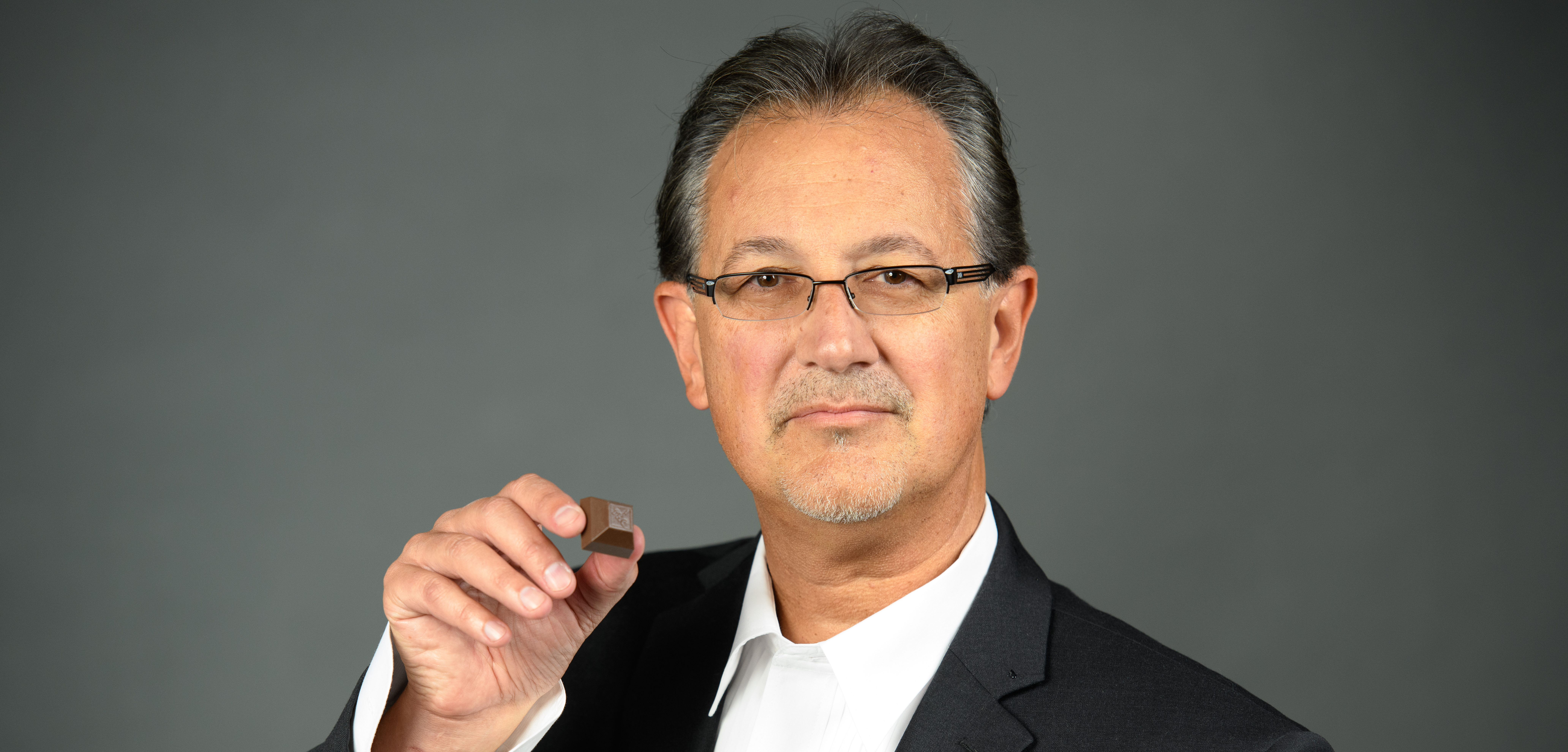 A shot of Rick Scarpello, Medically Correct CEO and Co-Founder, posed with a piece of Nove cannabis luxury chocolates.